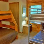The downstairs bedroom has a twin and twin over full bunk bed and sleeps four to five. Left Unit: Lower Bedroom