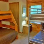The downstairs bedroom has a twin and twin over full bunk bed and sleeps four to five. Left Unit: Lower Bedroom